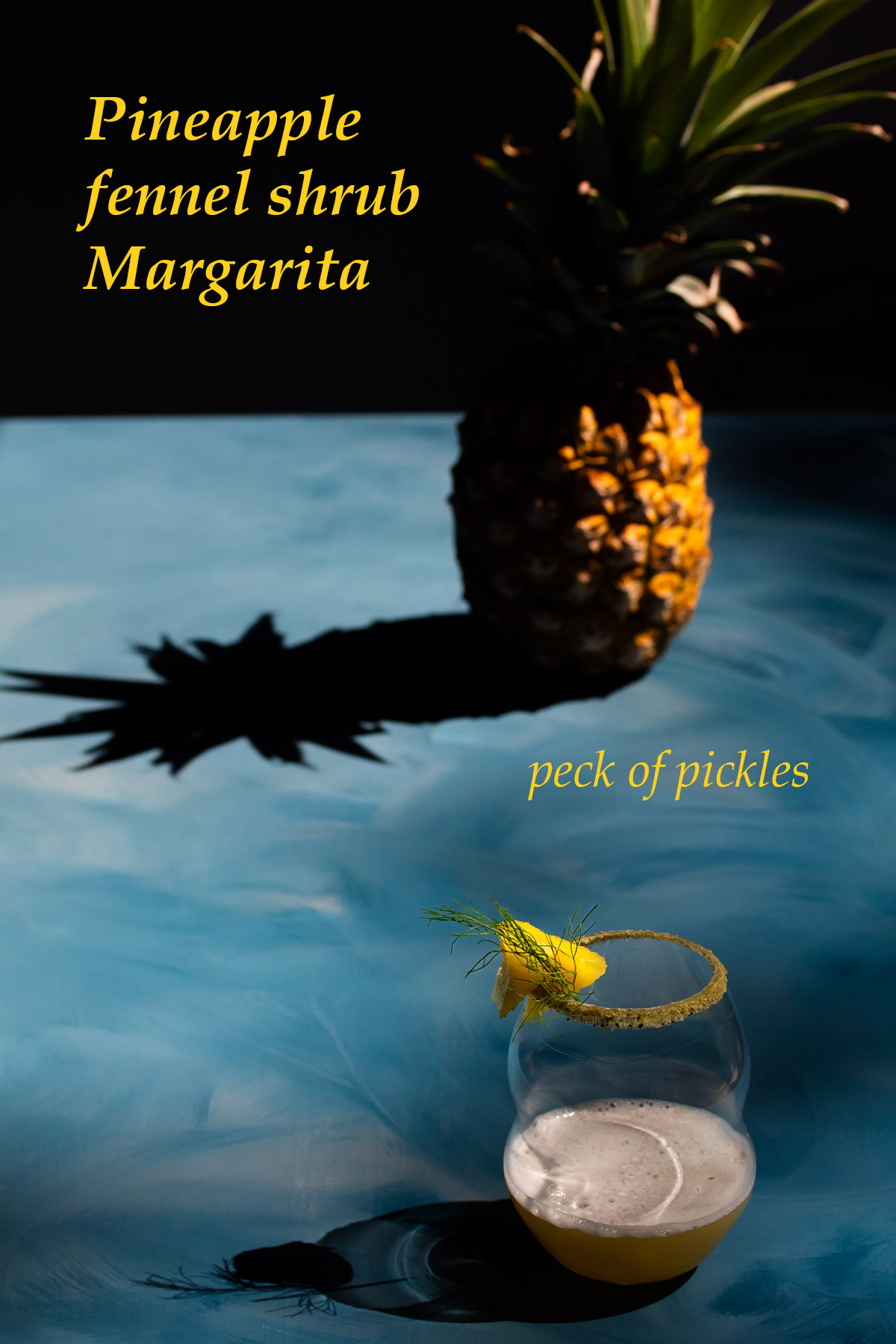 pineapple fennel shrub margarita cocktail with pineapple and shadow in background